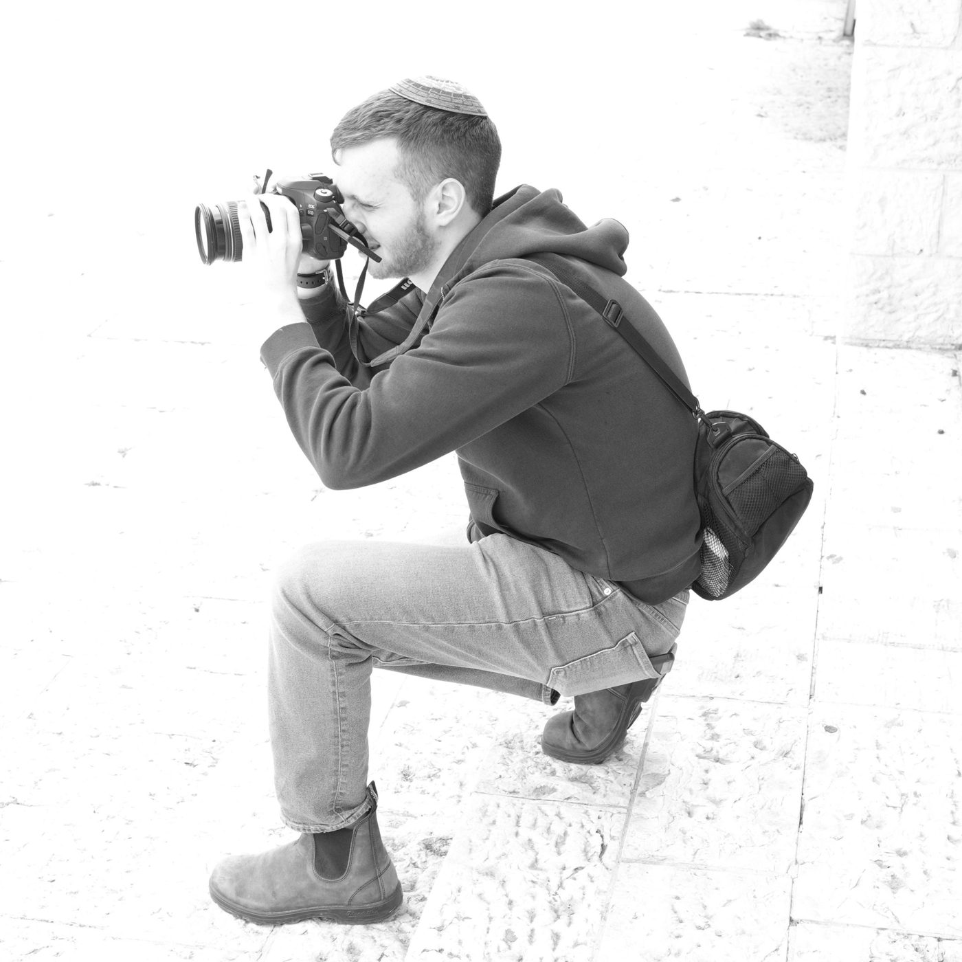 Shua crouching on stone steps, taking a photo